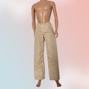 May include: A pair of beige striped pants with brown stripes. The pants are made of a soft, woven fabric.
