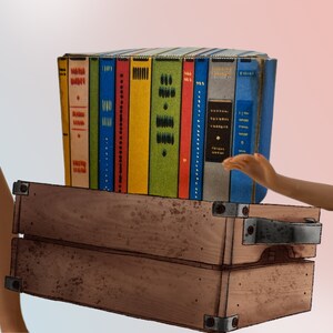 K&ouml;nnte beinhalten: Ein Stapel bunter B&uuml;cher mit verschiedenen Buchr&uuml;cken-Designs, der auf einem Holzkoffer im Vintage-Stil liegt. Die B&uuml;cher sind in Blau-, Gelb-, Gr&uuml;n- und Rott&ouml;nen gehalten. Ein Bein und ein Arm sind im Bild zu sehen.