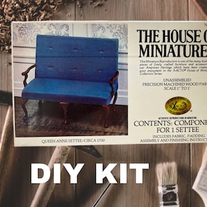 May include: A DIY kit for building a Queen Anne Settee, circa 1730. The kit includes precision machined wood parts, fabric, padding, and assembly instructions. The box features a photo of the finished settee, which is blue with button tufting.