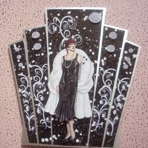 白い毛皮を着た女性が描かれたアールデコ調の黒いパネルカード