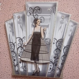 Tarjeta con panel metálico plateado estilo art déco con una dama vestida de negro (nuevo servicio directo al destinatario)
