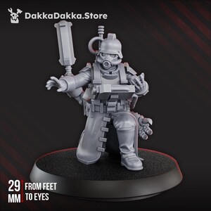 May include: A gray miniature figure of a soldier in a gas mask and helmet, kneeling on a black base. The figure is holding a weapon and has a detailed uniform. The text "29 from feet to eyes" is visible. The DakkaDakka.Store logo is in the top left corner.