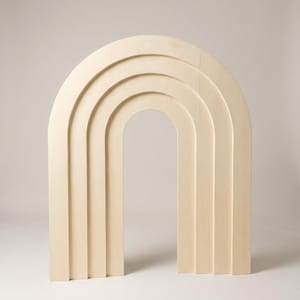 May include: A light-colored wooden arch structure featuring a series of four concentric, stepped semi-circular layers. The object has a smooth, natural wood grain finish and a symmetrical design with vertical sides that curve into a rounded top.