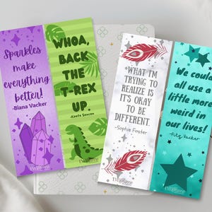 May include: Four colorful bookmarks with inspirational quotes. The bookmarks feature purple, green, white, and teal backgrounds with text and illustrations. One bookmark says "Sparkles make everything better!" and another says "Whoa, back the T-Rex up."