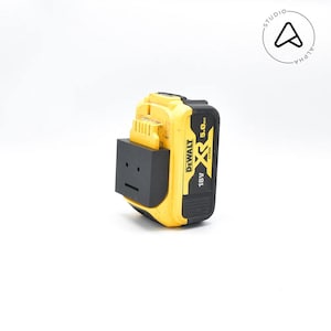 May include: A yellow and black DeWalt 18V XR 5.0Ah battery pack. The battery has a black adapter attached to the front. The battery is on a white background. The battery is a power tool accessory.