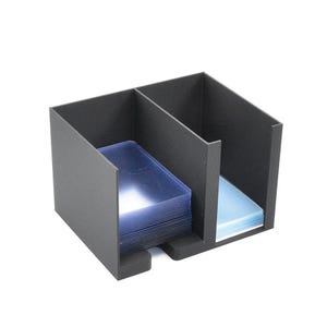 Könnte beinhalten: Ein schwarzer Kartenhalter mit drei Fächern. Jedes Fach enthält einen Stapel klarer, schützender Kartenhüllen. Der Halter besteht aus einem mattschwarzen Material und dient zur Kartenorganisation.