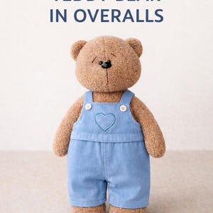 May include: A plush teddy bear wearing blue denim overalls with a heart-shaped patch. The bear is light brown with a black stitched nose and button eyes. The text "TEDDY BEAR IN OVERALLS" is above the bear. Finished size is 10 inches.
