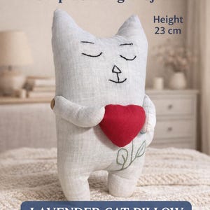 May include: A lavender cat pillow, approximately 9 inches tall, holding a red heart. The cat has embroidered eyes and a whimsical design. The text "Simple Sewing Project" and "Lavender Cat Pillow" are visible.