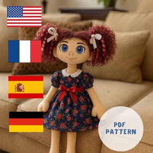 May include: A handmade rag doll with red curly hair styled in pigtails, adorned with white bows. The doll wears a blue floral dress with a red bow and matching red polka-dot shoes. The doll has blue eyes and a sweet expression.