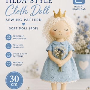 May include: A Tilda-style cloth doll sewing pattern for a 30 cm soft doll. The doll has curly white hair, a gold crown, and a light blue eyelet dress with a white lace hem. It holds a small bouquet of blue and white flowers in its hands.