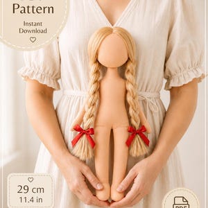 May include: A cloth doll with light skin and long blonde hair styled in two braids, each tied with a small red ribbon. The doll is featured in a PDF pattern for a cloth doll body, measuring 29 cm or 11.4 inches in height, available for instant download.