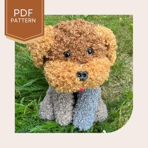 May include: A handmade plush dog with brown and tan curly fur, black eyes, and a pink tongue. The dog's body is gray and blue. The image includes a brown banner with the text "PDF PATTERN".