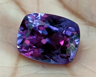 May include: A cushion-cut gemstone with a captivating display of colors. The gem showcases a blend of deep purples, vibrant pinks, and hints of blue, creating a mesmerizing play of light and shadow. The facets are precisely cut, enhancing the stone's brilliance.