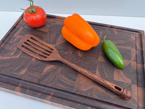A hand-carved teak fish spatula made in the USA — the specific form factor and premium material make this a genuinely tool-nerd-worthy kitchen find.