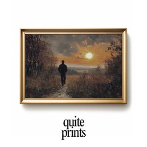 May include: A framed landscape painting shows a person walking towards a sunset. The artwork has a golden frame, a warm colour palette, and the text "quite prints" at the bottom.