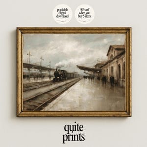 Op de afbeelding: Een ingelijste vintage print van een treinstationscène. Het kunstwerk toont een stoomtrein op de rails, mensen op het perron en een gebouw met boogvensters. De print heeft een goudkleurige lijst en de tekst "quite prints" onderaan.