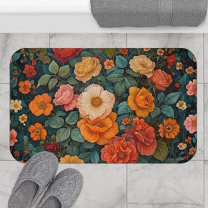 Könnte beinhalten: Eine rechteckige Badematte mit einem lebendigen Blumenmuster. Die Matte zeigt einen dunklen Hintergrund mit einer Vielzahl farbenfroher Blumen, darunter Rosen und Mohnblumen, in Orange-, Gelb- und Rosatönen, umgeben von grünen Blättern.