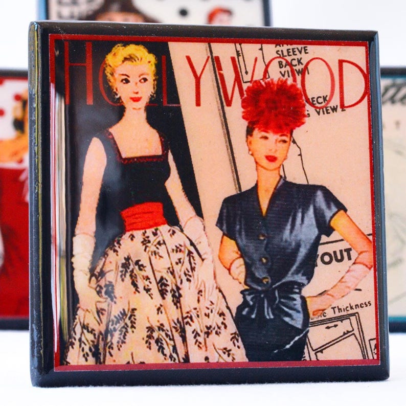 May include: A vintage magazine cover featuring two women in stylish dresses. The magazine is titled "Hollywood" and has a red and black color scheme.