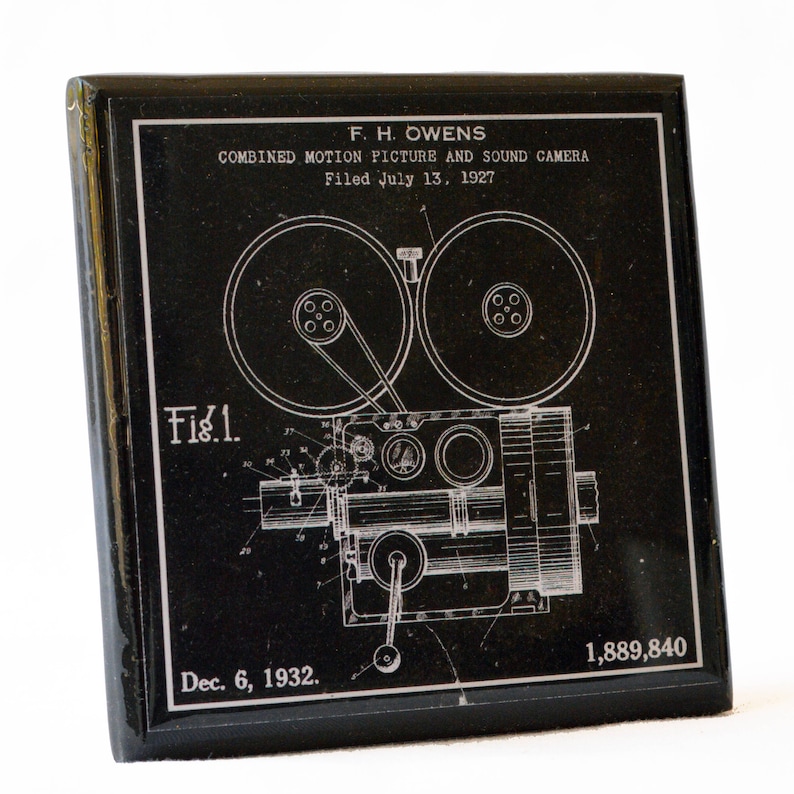 May include: A black and white patent drawing of a combined motion picture and sound camera. The drawing shows the camera's internal workings, including gears, sprockets, and a lens. The patent was filed on 13 July 1927, and granted on 6 December 1932, to F.H. Owens. The patent number is 1,889,840.