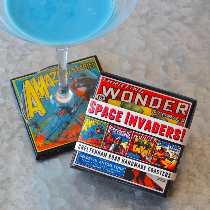 May include: Two square coasters with a vintage comic book design. The coasters feature images of spaceships, robots, and other sci-fi themes. The text on the coasters reads "Amazing Stories", "Thrilling Wonder Stories", "Space Invaders!" and "Secret of Anton York".