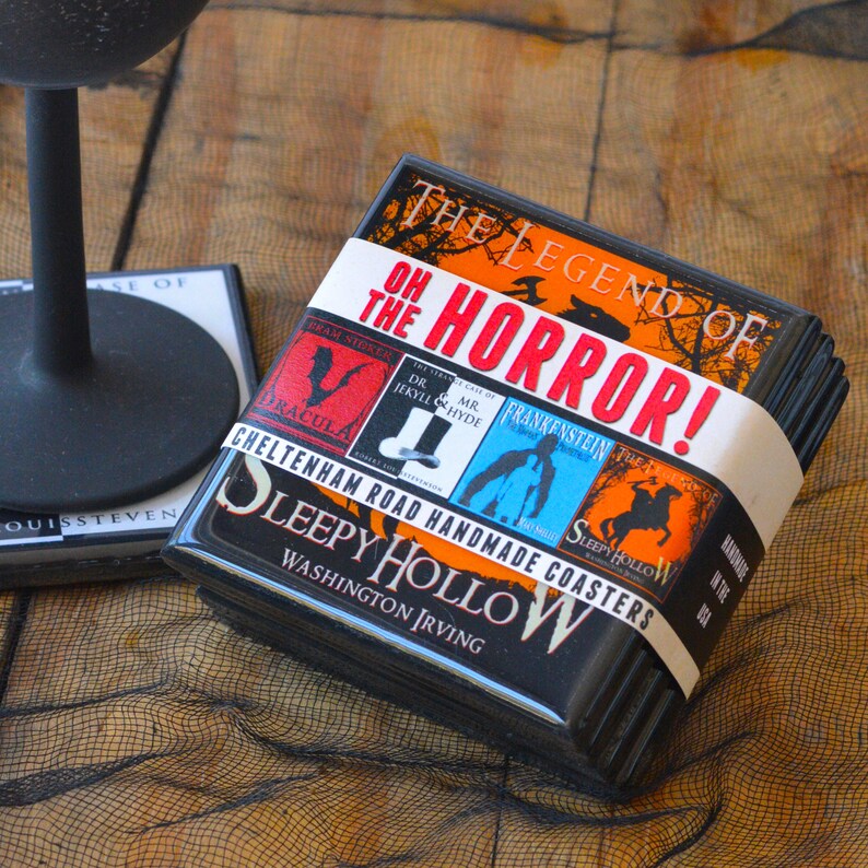 May include: A stack of black square coasters with a white band featuring the text "OH THE HORROR!" and book covers like Dracula, Dr. Jekyll & Mr. Hyde, Frankenstein, and Sleepy Hollow. The coasters are handmade in the USA.