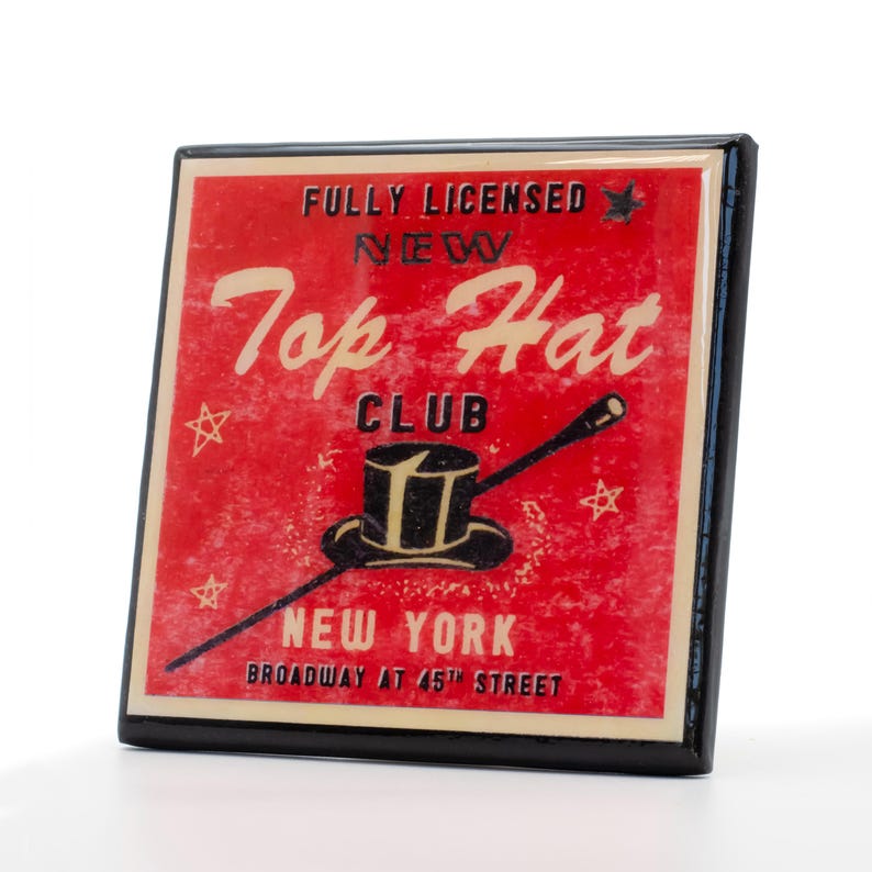 以下が含まれることがあります： 「Fully Licensed New York Top Hat Club Broadway at 45th Street」と黒文字で書かれた、赤と白のヴィンテージスタイルの看板。看板には、白いバンドが付いた黒いシルクハットと、黒い先端が付いた白い棒が描かれている。