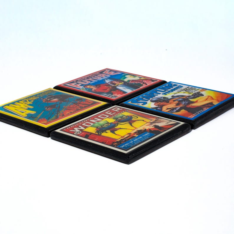 May include: Four square coasters with vintage comic book covers. The covers feature illustrations of a man in a red suit, a man in a blue suit, a man in a green suit, and a man in a yellow suit. The coasters are black with a wood grain finish.