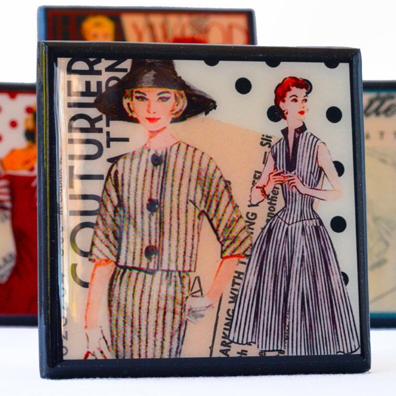May include: Two vintage fashion illustrations on a black square tile. The illustration on the left shows a woman wearing a striped dress and jacket. The illustration on the right shows a woman wearing a striped dress with a polka dot background. The text "Couturier Pattern" is visible on the left side of the tile.