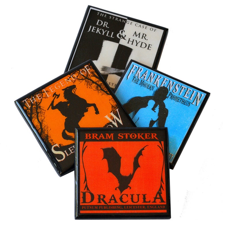 May include: A collection of square magnets featuring classic horror literature titles. Titles include "Dracula," "Frankenstein," "The Legend of Sleepy Hollow," and "Dr. Jekyll & Mr. Hyde." Each magnet has a black border and a unique color scheme.