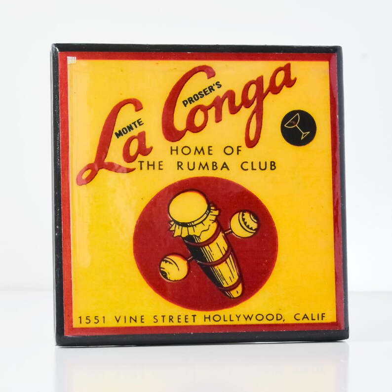 May include: A vintage-style sign for La Conga, Proser's Home of the Rumba Club, located at 1551 Vine Street Hollywood, Calif. The sign features a yellow background with red and black lettering. A red circle with a stylized illustration of a conga drum and maracas is in the center of the sign.