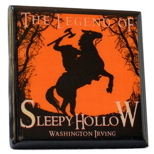 May include: Square magnet featuring a black silhouette of the Headless Horseman on horseback, holding an axe, against an orange background. The text "The Legend of Sleepy Hollow" and "Washington Irving" are displayed in white and gold.