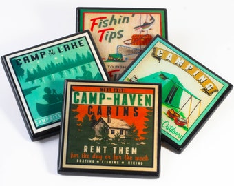 May include: Four vintage-style coasters with different designs. The first coaster has a green and blue design with the text "Camp by the Lake" and "Campsite". The second coaster has a green and yellow design with the text "Fishin' Tips" and "To Fish". The third coaster has a green and white design with the text "Camping" and "Outdoors". The fourth coaster has a red, orange, and green design with the text "Next Exit: Camp-Haven Cabins" and "Rent Them for the day or for the week. Boating, Fishing, Hiking."