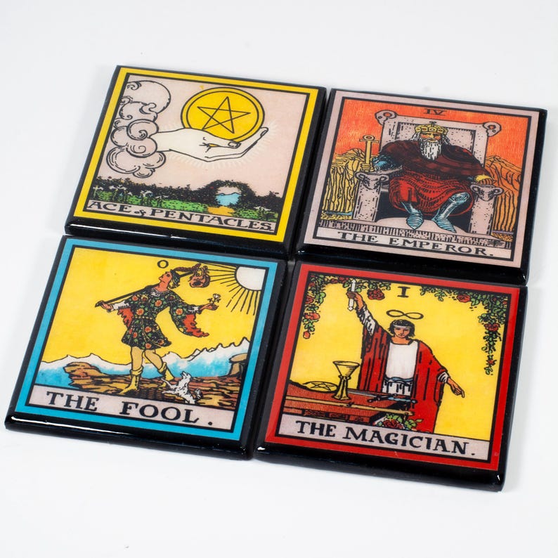May include: Four square coasters with tarot card designs. The coasters feature images of "Ace of Pentacles", "The Emperor", "The Fool", and "The Magician". Each coaster has a black border and vibrant colors.