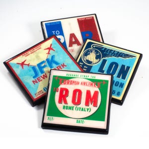 Peut inclure: Quatre étiquettes à bagages de style vintage avec des bordures noires. Les étiquettes sont pour des vols vers JFK, Paris, Rome et Londres. Les étiquettes sont de différentes couleurs, notamment rouge, bleu, vert et blanc.