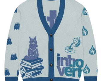 May include: Light gray cardigan with a blue trim and button closure. The sweater features a cat sitting on books, ghost and flame graphics, and the word "introvert" in blue. A cozy, casual style.