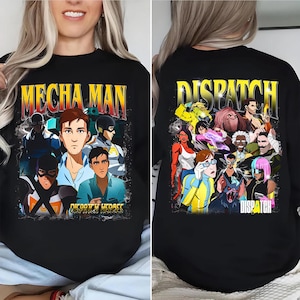 May include: Black sweatshirt with a vibrant graphic design. The front features the text "MECHA MAN" above illustrated characters. The back displays the word "DISPATCH" above a group of illustrated characters. The sweatshirt is a casual garment.