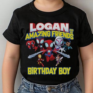 May include: Black t-shirt featuring a colorful graphic of Spider-Man and friends with the text "LOGAN AND HIS AMAZING FRIENDS BIRTHDAY BOY". The design includes various characters in a cartoon style.