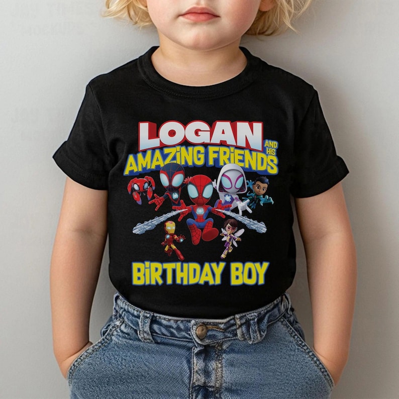 May include: Black t-shirt featuring a colorful graphic of Spider-Man and friends with the text "LOGAN AND HIS AMAZING FRIENDS BIRTHDAY BOY". The design includes various characters in a cartoon style.