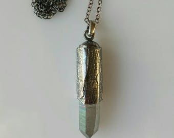 Blueish crystal point set in a silver lace cone