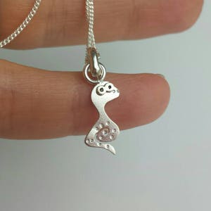 Op de afbeelding: Een zilveren slangenhangerketting met een gedetailleerd ontwerp. De slang is opgerold met zijn staart in zijn bek.