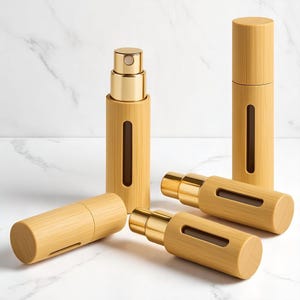 May include: A collection of bamboo-style perfume atomizers with gold-colored spray mechanisms. The atomizers are cylindrical, with a small rectangular window to view the contents. The bamboo has a light brown color.
