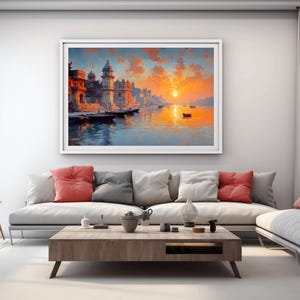 May include: A framed landscape painting depicts a vibrant sunset over a river with boats and buildings. The artwork features warm colors like orange, red, and blue, creating a serene and picturesque scene. The painting is displayed above a modern sofa.