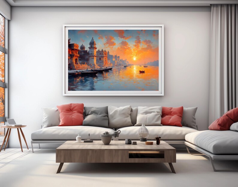 May include: A framed landscape painting depicts a vibrant sunset over a river with boats and buildings. The artwork features warm colors like orange, red, and blue, creating a serene and picturesque scene. The painting is displayed above a modern sofa.