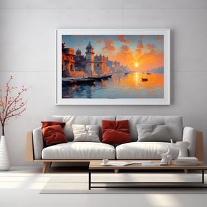 May include: A framed landscape painting depicts a vibrant sunset over a river with buildings and boats. The artwork features warm colors, including orange, yellow, and blue, creating a serene and picturesque scene. The painting is displayed above a modern sofa.
