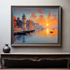 May include: A framed landscape painting depicts a vibrant sunset over a river with boats and buildings. The artwork features warm orange and yellow hues, with a dark frame. A dark vase sits on a decorative wooden table.