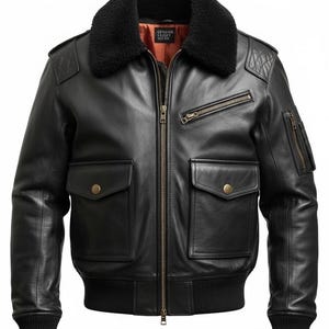 Puede incluir: Chaqueta bomber de cuero negro con cuello de borrego negro, dos bolsillos delanteros y un bolsillo en el pecho con cremallera. La chaqueta tiene un dobladillo y puños de punto acanalado. El interior es naranja y tiene el texto "GENUINE LEATHER".