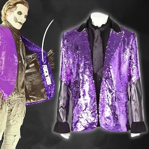 May include: A purple sequined blazer with black leather sleeves and cuffs. The blazer is paired with a black shirt and a gray tie. The lining of the blazer has the text "FUCK YOU".