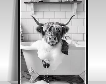 May include: Black and white framed print of a Highland cow in a bathtub filled with bubbles. The cow is looking directly at the viewer, with its horns visible. The background includes a white tiled wall and a shelf with toiletries.