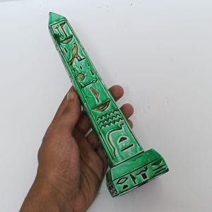 Green Egyptian obelisk with hieroglyphs – pharaonic decorative art piece.