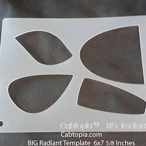 May include: A white plastic template with four cut-out shapes. The template is labeled "BIG Radiant Template 6x7 5/8 Inches".